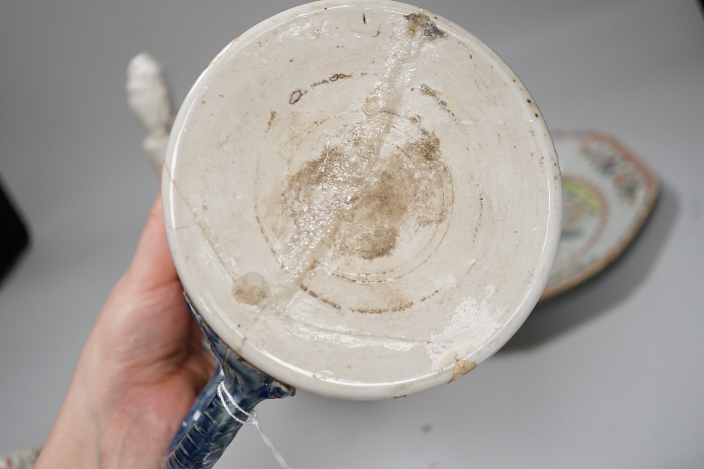 A Chinese figure of blanc de chine, a dragon tea bowl, a saucer, a large tankard, and another Chinese dish, tallest 23cm